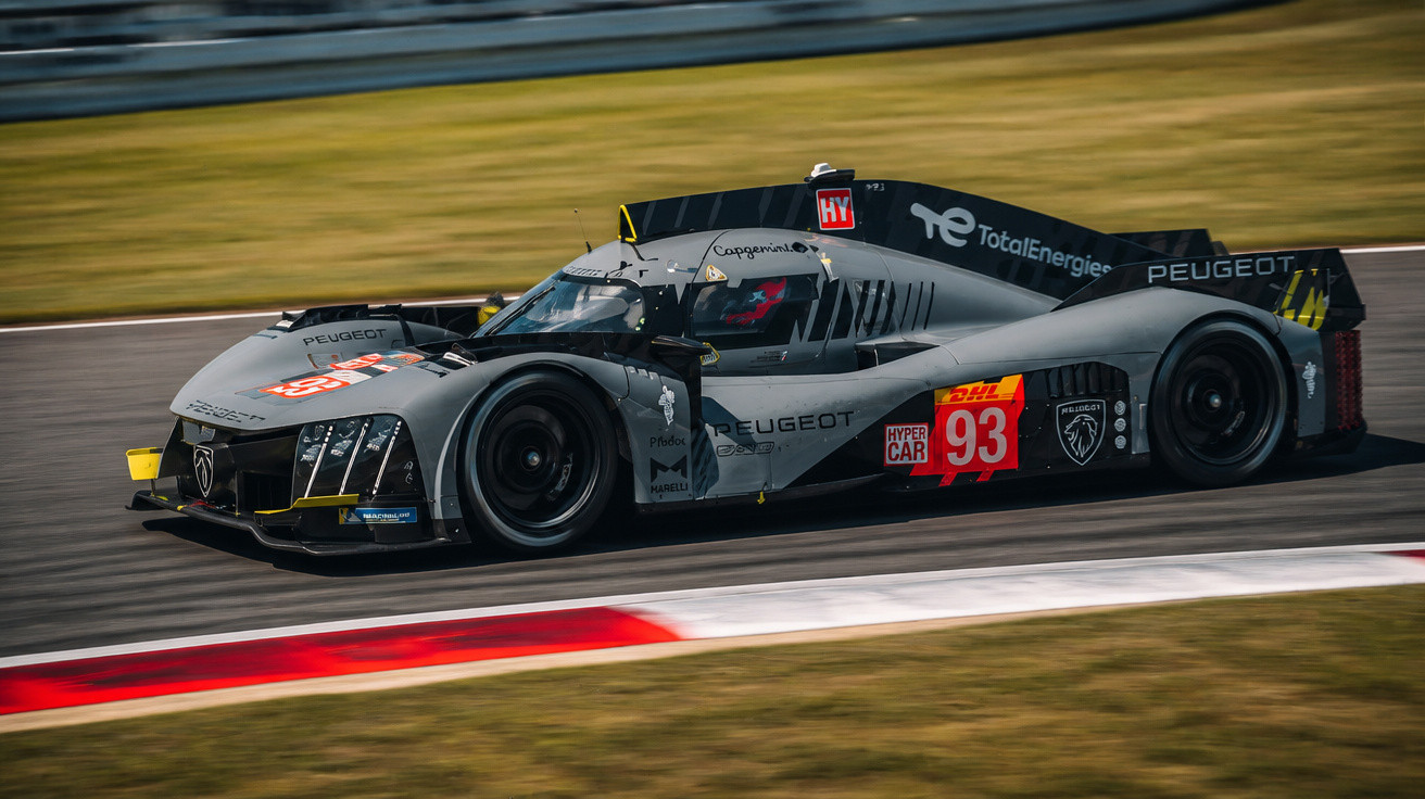 Carro de corrida Peugeot cinzento com número 93 em pista de circuito, em velocidade.